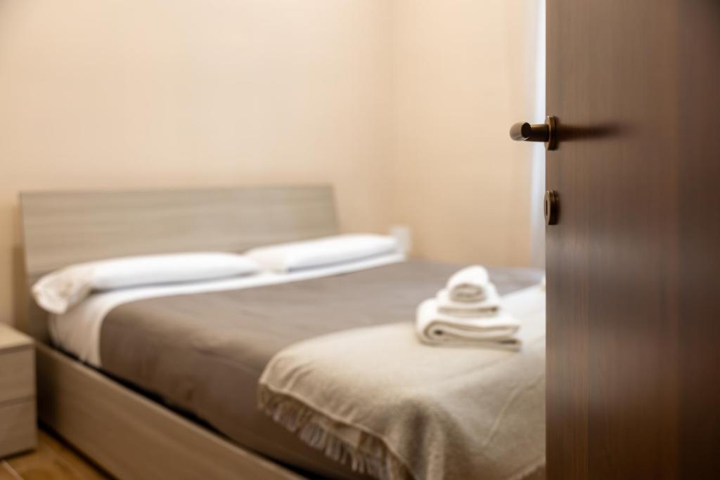 1 dormitorio con 1 cama con 2 toallas en Casa Vacanze Alla Maison, en Fiumicino