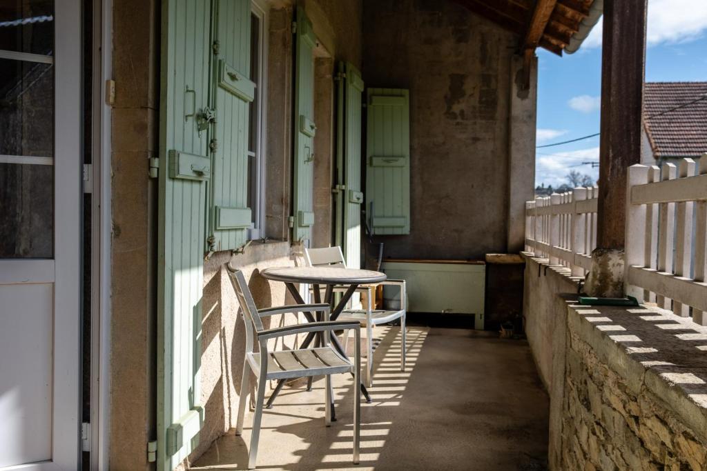 een tafel en stoelen op de veranda van een huis bij Wine-grower's House At Pras-burgundy in Genouilly