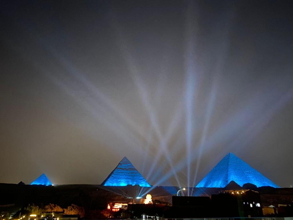 a fountain in front of the pyramids at night at Pyramids Express Hotel in Cairo