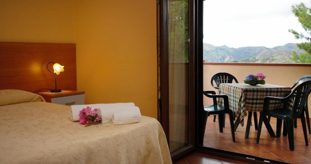 a bedroom with a bed and a table and chairs at B&B Fort Apache in Monforte San Giorgio