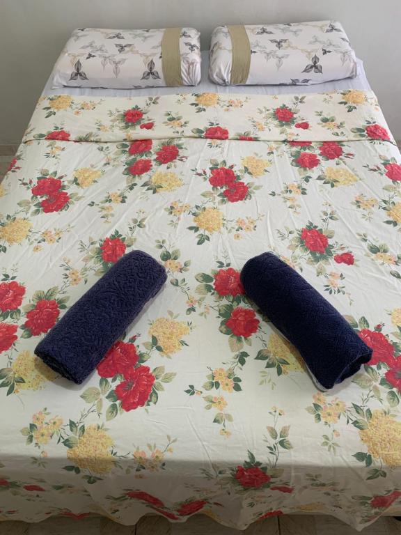 duas almofadas numa cama com flores em Quarto confortável perto de tudo 03 em Belém