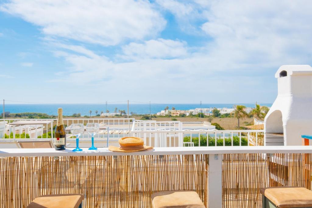 una mesa en un balcón con vistas al océano en Villa Maridoro by HDSalento, en Lido Marini