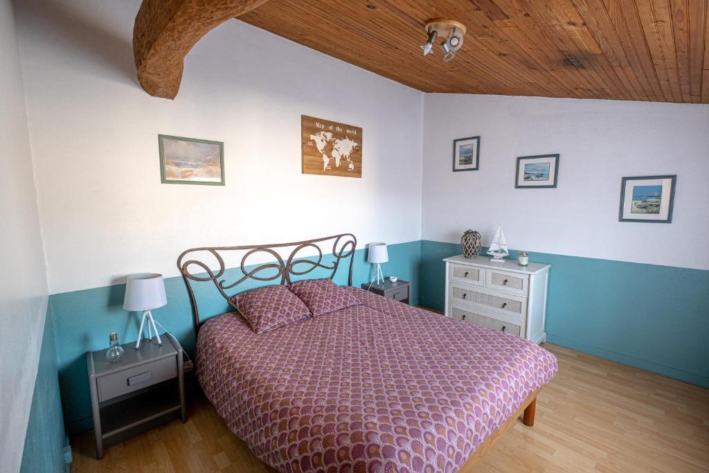 ein Schlafzimmer mit einem Bett und einer Holzdecke in der Unterkunft Coeur de Charente Maritime, venez respirez. in Saint-Germain-de-Marencennes
