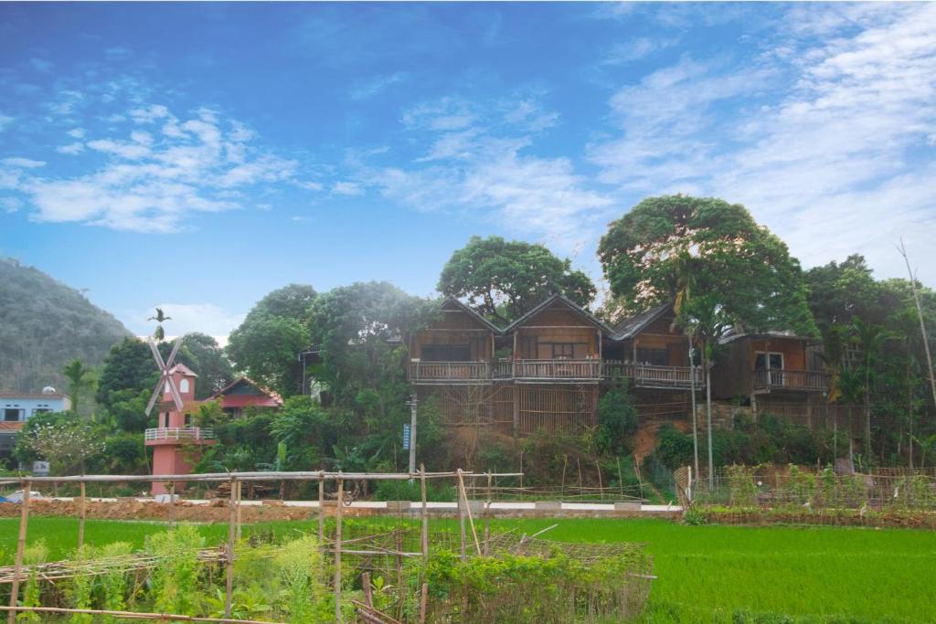 un grupo de casas en medio de un campo en Mai Chau La Vida Homestay, en Mai Chau