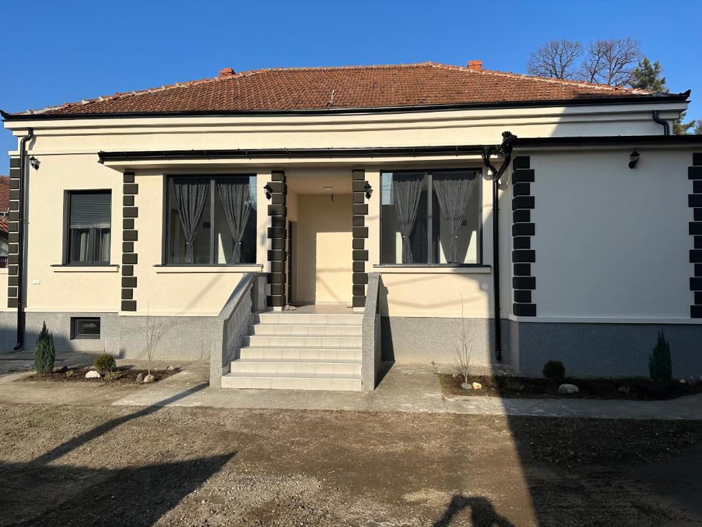 une maison blanche avec deux fenêtres et une porte dans l'établissement Apartmani M.&.B Luks 2, à Mataruška Banja