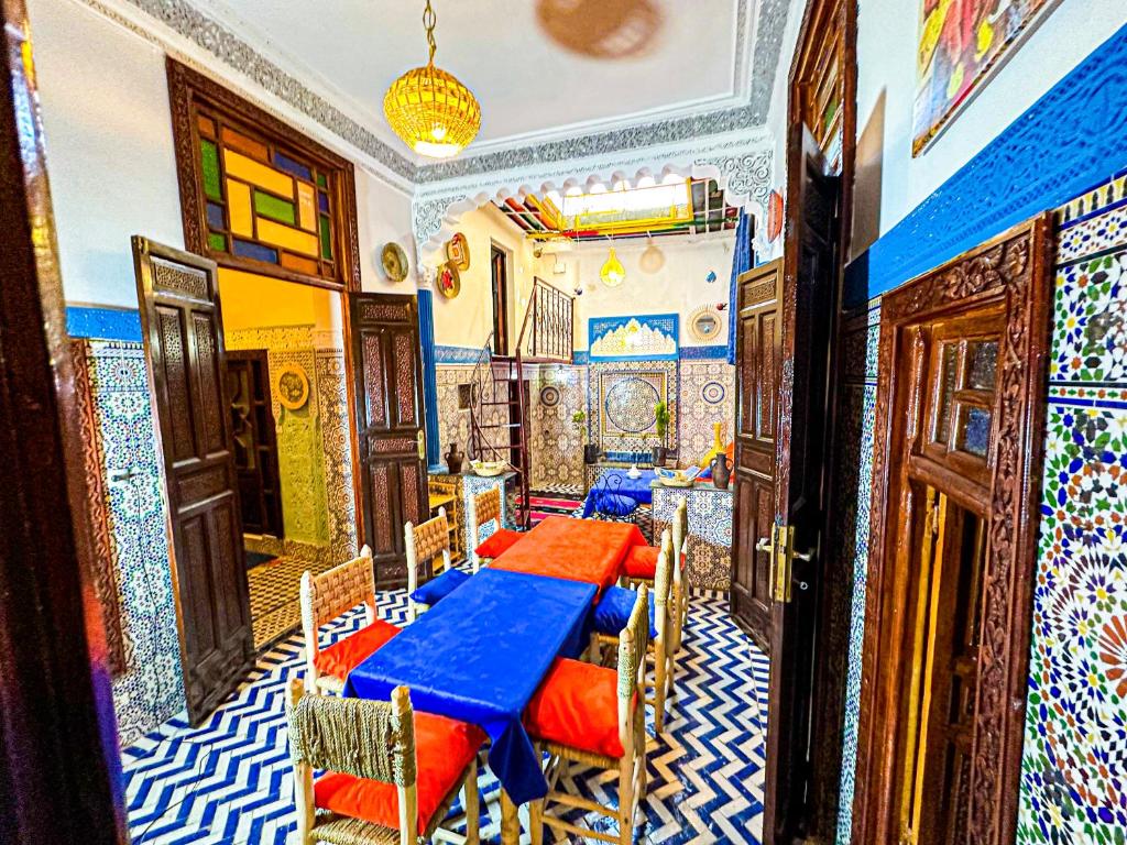 un comedor con 2 mesas en una sala con mosaicos en Hostel Speakeasy Fes, en Fez