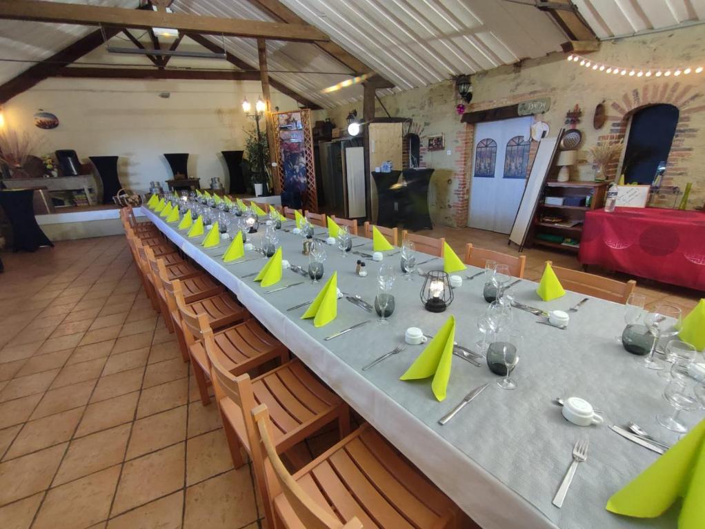 a long table with green napkins and wine glasses at Résidence L&#39;Ogomé in Le Boupère