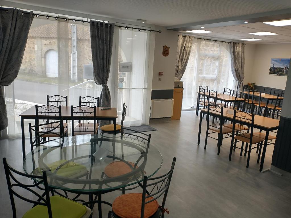 a room with tables and chairs and a glass table at Résidence L&#39;Ogomé in Le Boupère