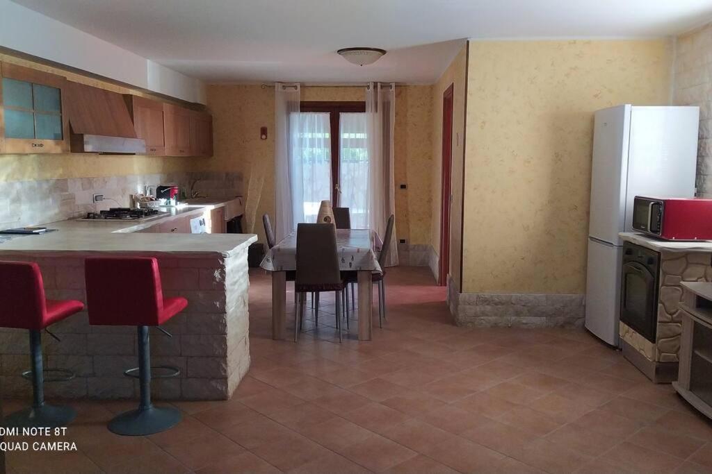 eine Küche mit einem Tisch und Stühlen sowie einem Kühlschrank in der Unterkunft Open Space da Luca e Laura,a 7 minuti da Alghero. in Olmedo
