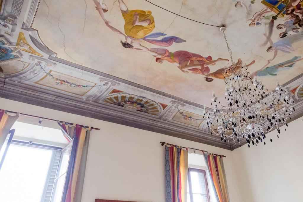 um quarto com um tecto com um lustre em B&B Stupido Hotel em Florença