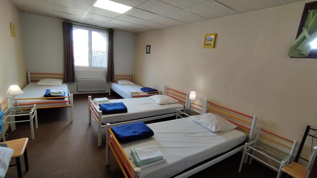 a hospital room with three beds and a window at Résidence L&#39;Ogomé in Le Boupère