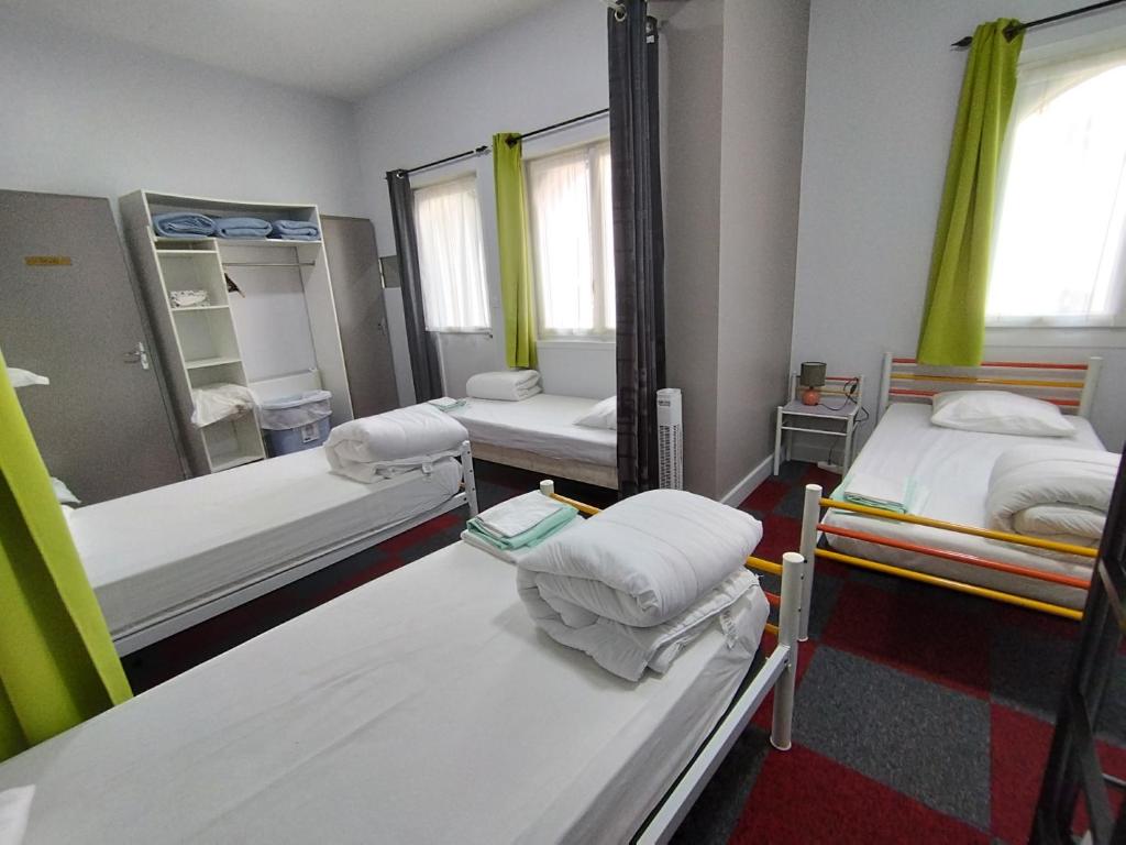 a hospital room with two beds and a mirror at Résidence L&#39;Ogomé in Le Boupère