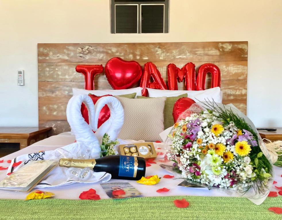 ein Bett mit einem Blumenstrauß und Schwänen in der Unterkunft Pouso das Flores - Próximo a Maria Fumaça in Tiradentes