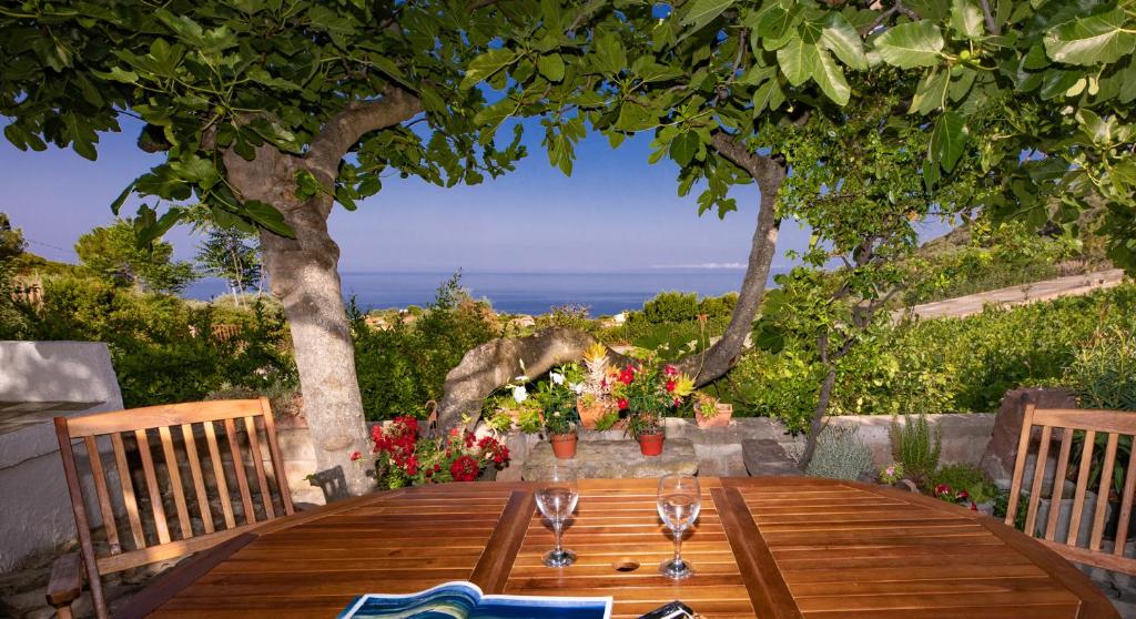 - une table en bois avec des verres à vin dans l'établissement Welcomely - Badde Nuraghe dimora vista mare con parcheggio privato, à Magomadas