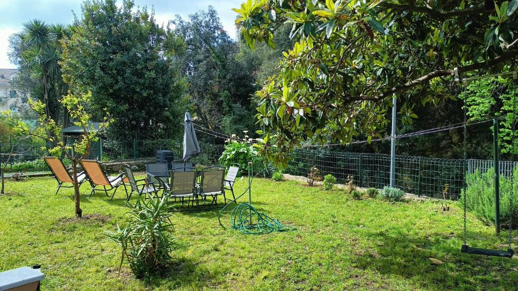 a group of chairs and an umbrella in a yard at Nanin's Home in Sori