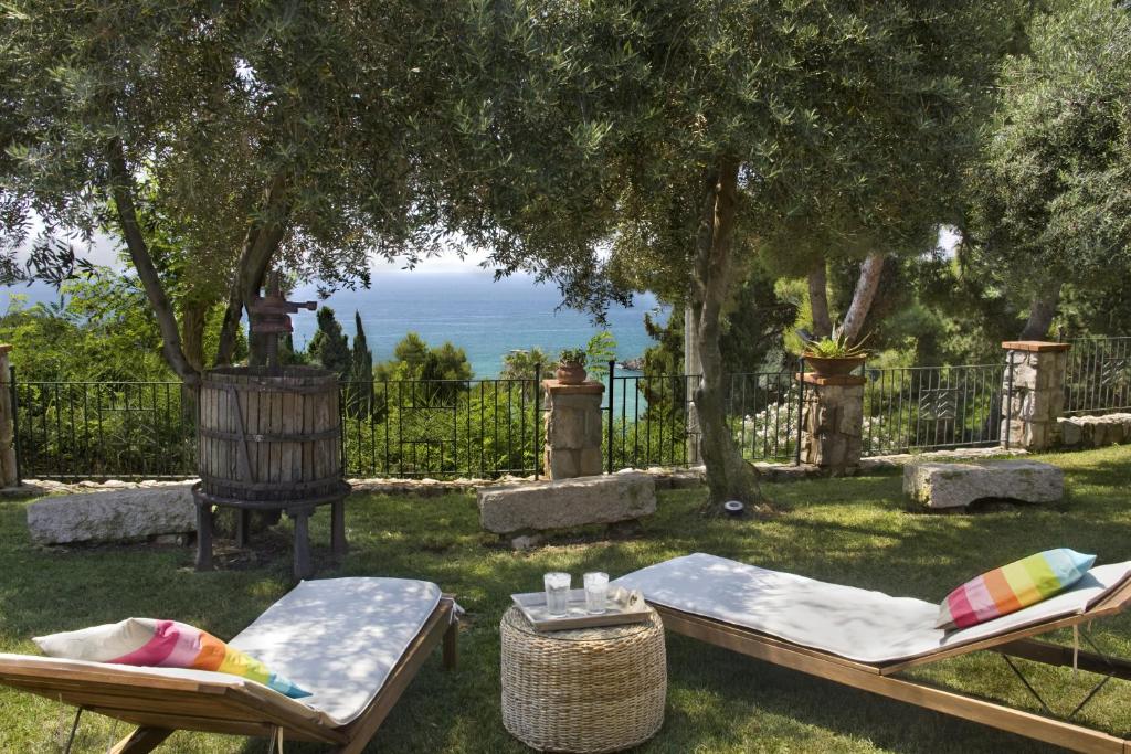 un jardín con 2 sillas y una mesa con vistas al océano en Villa Michela tra Cielo e Mare, en Gaeta