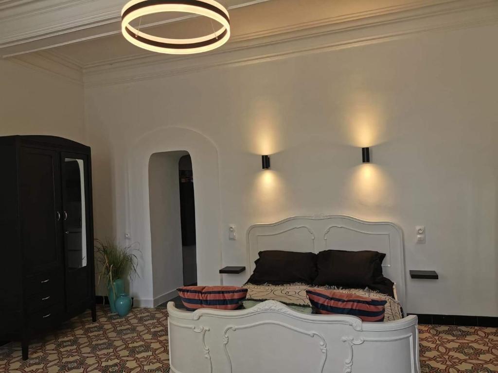 フルーリーにあるPlace Jean Moulin Roomのベッドルーム(白いベッド1台、シャンデリア付)