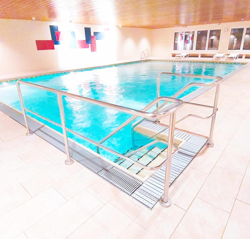 a large swimming pool with a stairway leading into it at Sonnen-Juwel mit Pool - Sauna direkt an der Skipiste in Missen-Wilhams