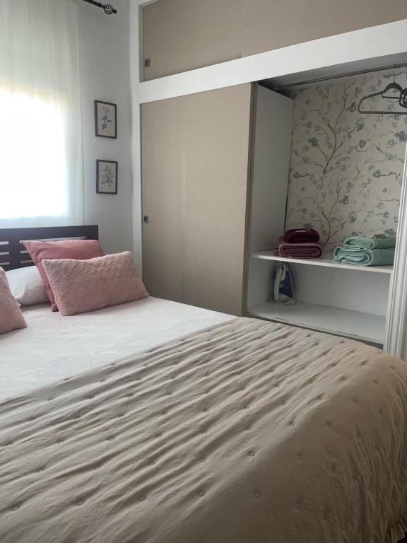 um quarto com uma cama grande e almofadas cor-de-rosa em CASA MALENI em Altea