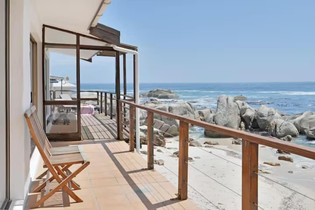 a balcony with a chair and a view of the ocean at The Bakoven Rock in Cape Town