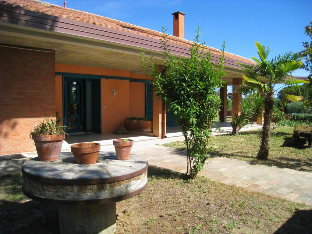 a house with three potted plants in front of it at Villa Formica - Vista su Castello di Gradara in Gradara