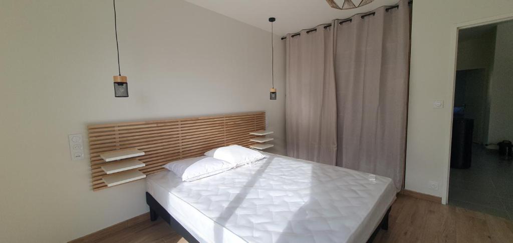 um quarto com uma cama com lençóis brancos e almofadas em Maison d'hôtes Proche du port de la Roche-Bernard. em Férel