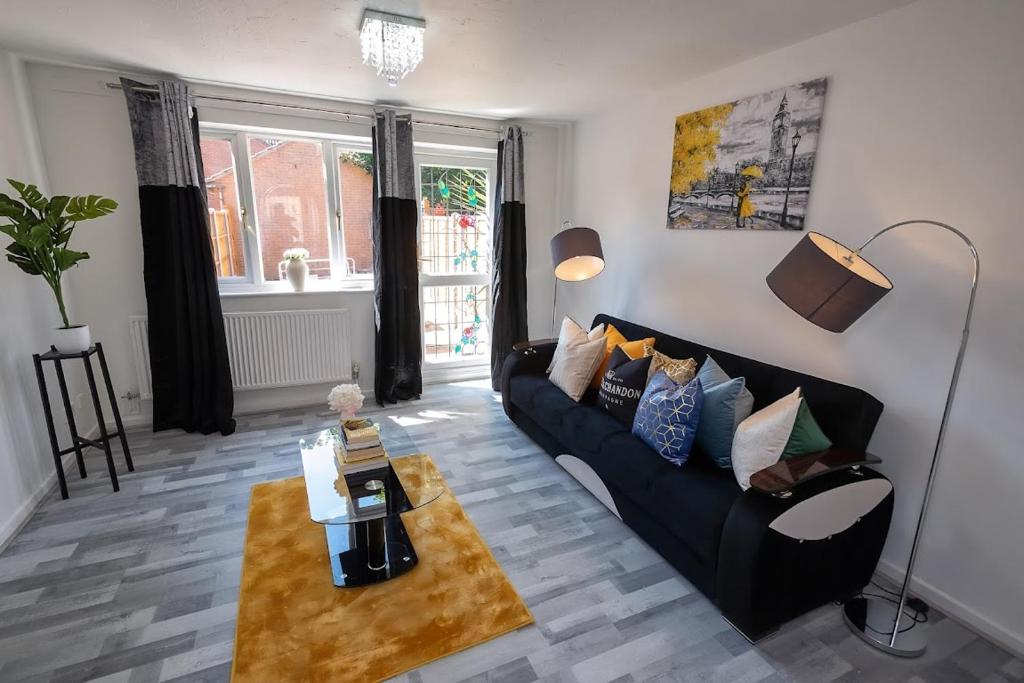 a living room with a black couch and a coffee table at I Love London! A Stunning 2 Bed Home Sleeps 1-3! in London