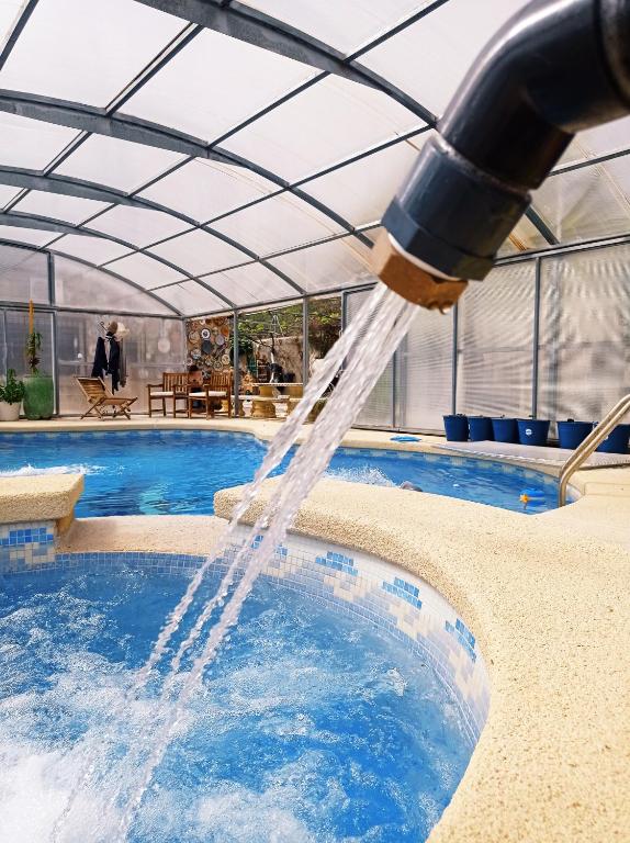 a person is pouring water into a swimming pool at Cortijo El Pilón in Vélez Blanco