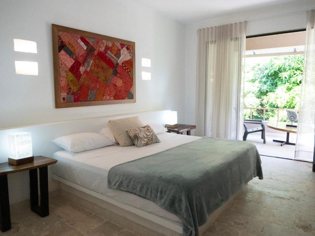 a bedroom with a bed with a painting on the wall at Hukumeizi Minca in Santa Marta