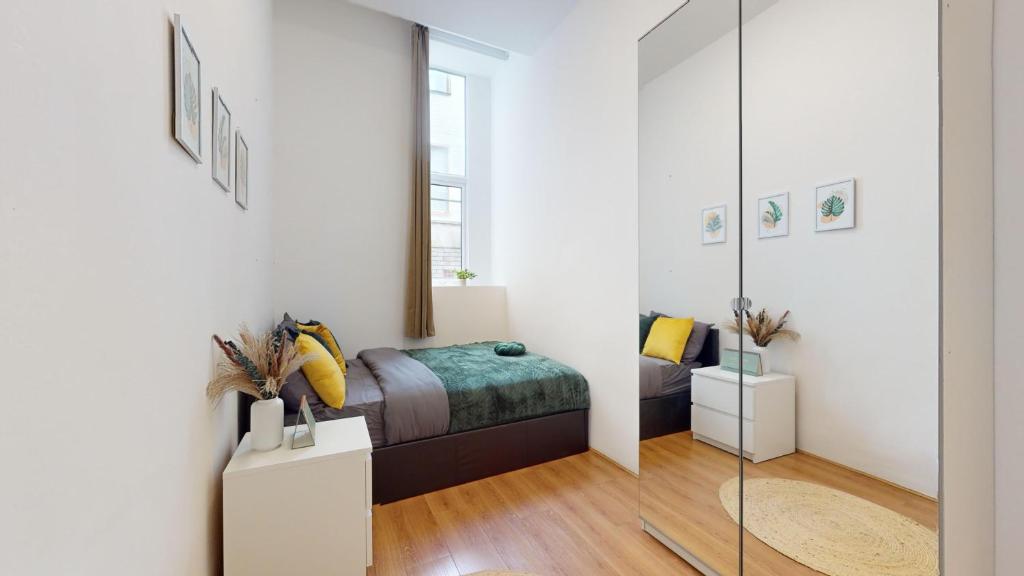 a bedroom with a bed and a mirror at Small & Cosy 1 Bedroom Flat in London
