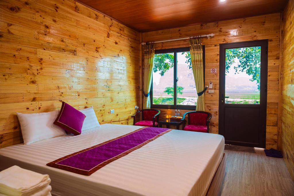 ein Schlafzimmer mit einem Bett und einer Holzwand in der Unterkunft Tam Coc Moutainside Homestay in Ninh Bình