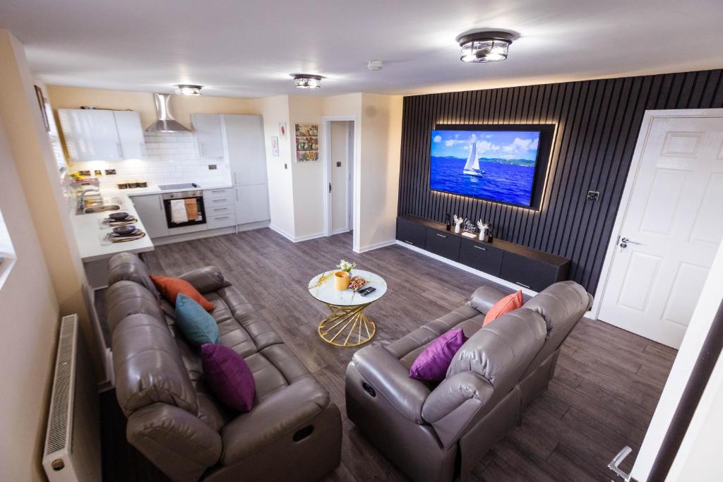 uma sala de estar com um sofá e uma televisão em Two Bedroom Luxury RB Home em Stalybridge