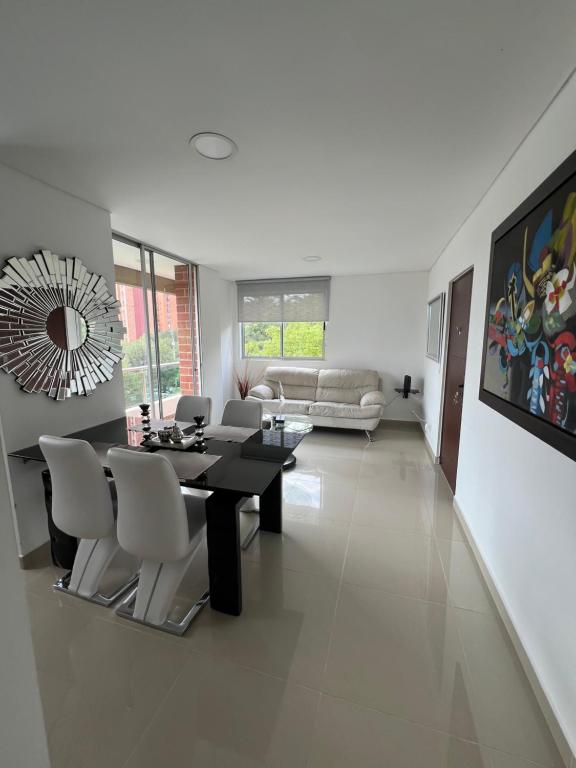 a dining room and living room with a table and chairs at Luxor apartamentos in Medellín