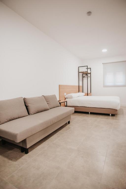 a living room with two beds and a couch at Polorooms in Zaratán