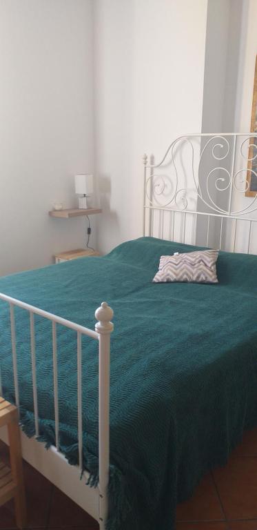 ein Schlafzimmer mit einem Bett mit einer grünen Bettdecke in der Unterkunft Locanda - Casa Vacanza Cascina Ronco in Erba