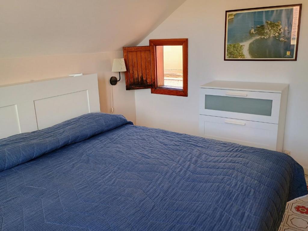 ein Schlafzimmer mit einem blauen Bett und einem Fenster in der Unterkunft Holiday Home Recanati in Giardini-Naxos