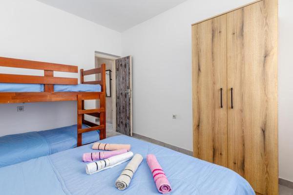 a room with a bed with four pillows on it at Apartments Ivo Bozinovic in Tivat