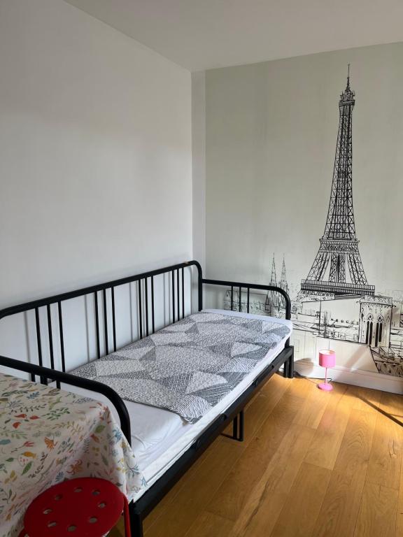 - une chambre avec un lit et la tour Eiffel dans l'établissement Studio indépendant cœur Paris 13ème, à Paris