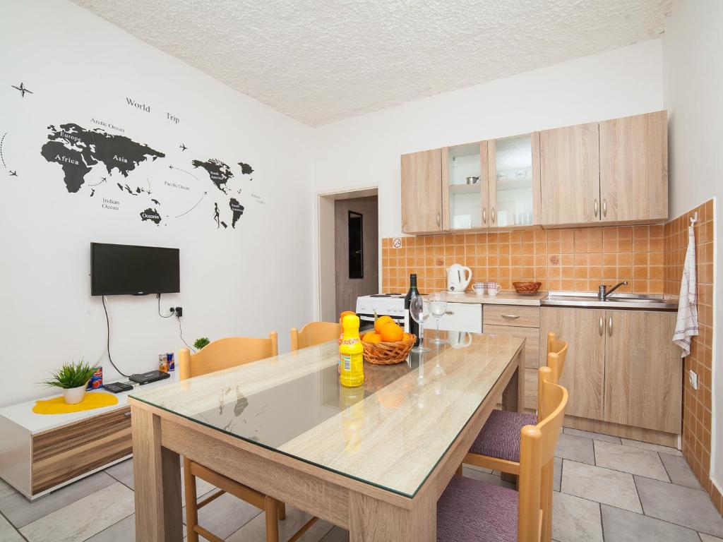 a kitchen with a large wooden table in a room at Apartments Ivo Bozinovic in Tivat