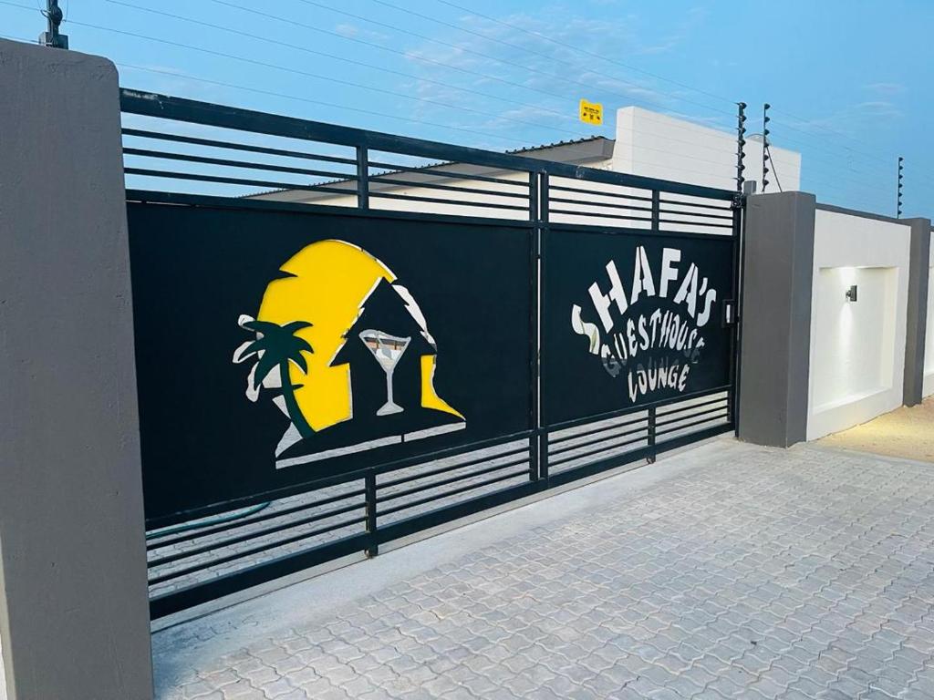 Shafas Guest House في روندو: سور اسود مع جدار عليه لافته