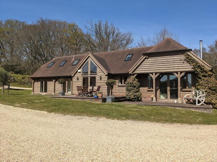 a large wooden house with a gambrel roof at The Barn New Forest Free Paddle boarding & free Zip wire. in Ringwood