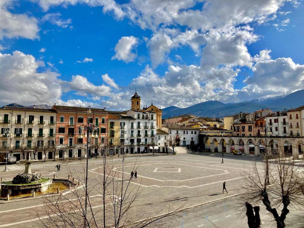 a city square with buildings and a blue sky with clouds at La Casetta In Piazza in Sulmona