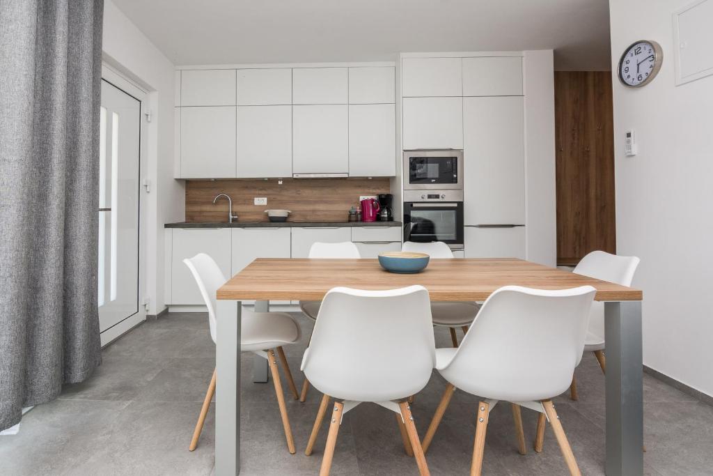 a kitchen with a wooden table and white chairs at Ferienwohnung mit Terrasse in Vir