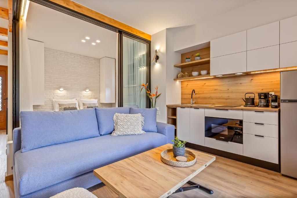 a living room with a blue couch and a table at Lola Apartments in Liapades