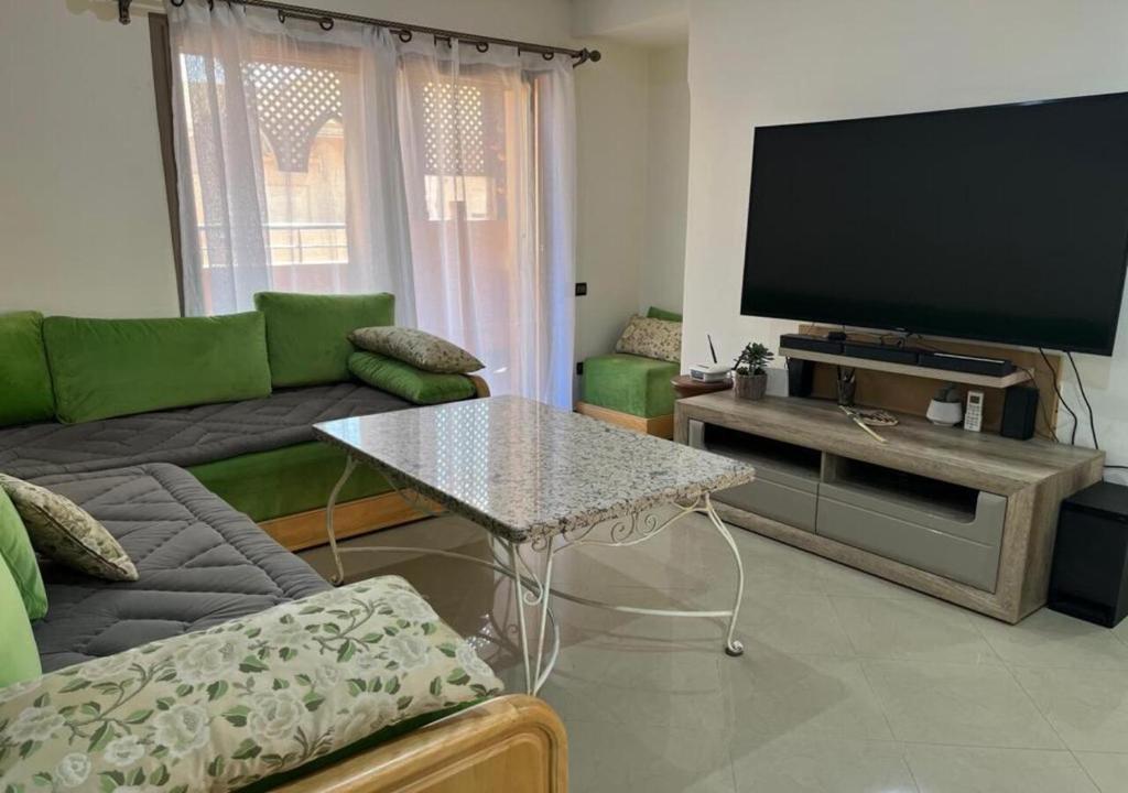 ein Wohnzimmer mit einem Sofa und einem TV in der Unterkunft Atla's Ruby in Marrakesch