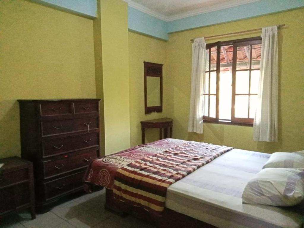 1 dormitorio con 1 cama, vestidor y ventana en Kondominium pantai crita by lukman, en Sukarame