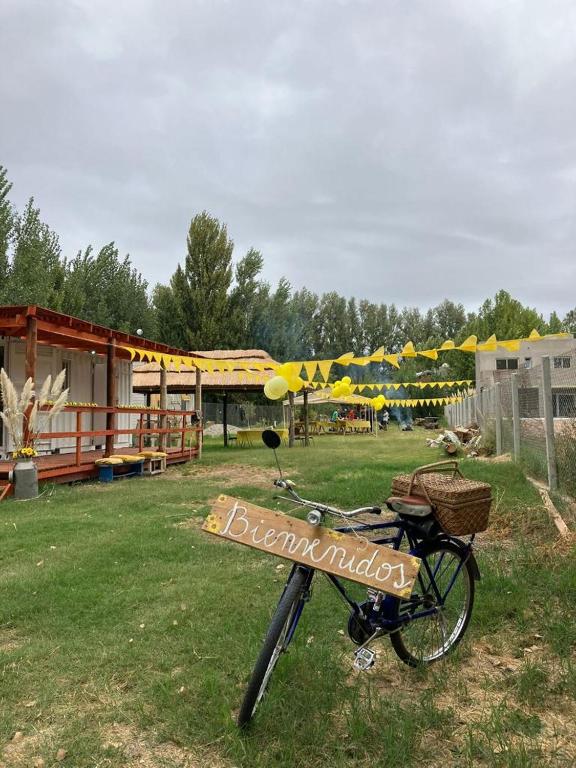 a bike parked in the grass with a sign on it at La Campigna, Neuquen in Plottier