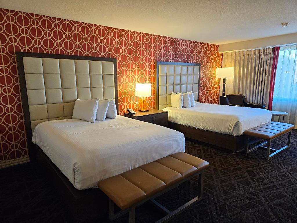 ラスベガスにあるPerfect Spot Unit by Horseshoe Casino Strip Las Vegasの赤い壁紙のホテルルーム内のベッド2台