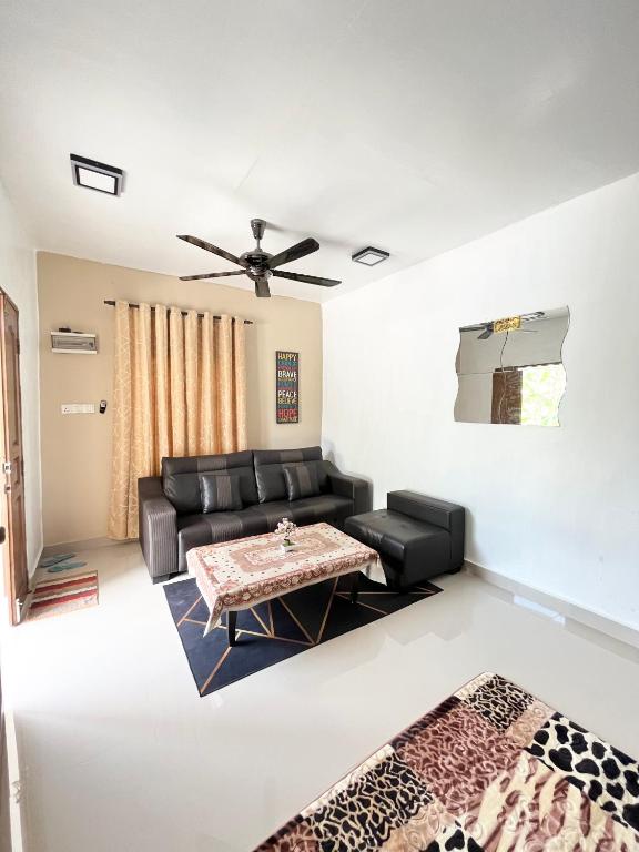 uma sala de estar com um sofá e uma mesa em Baiduri Homestay em Kota Tinggi