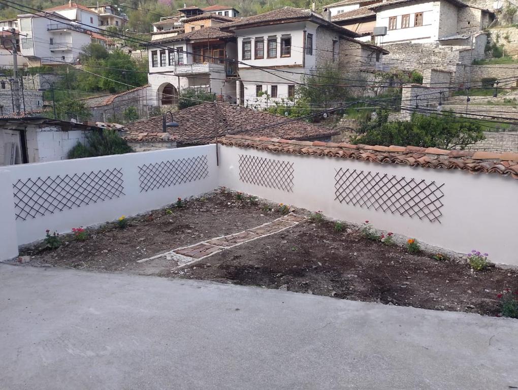 a white fence in a yard with houses at Te MuzzeU Hostel in Berat